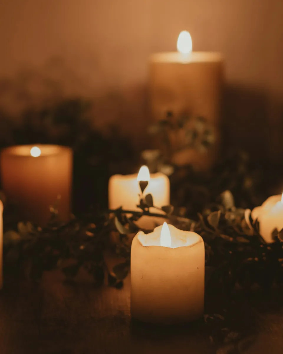 Group of lit candles among greenery